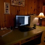 desk with computer in dark corner of room