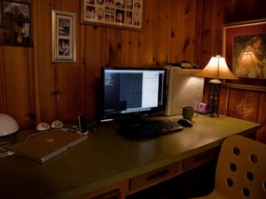 desk with computer in dark corner of room