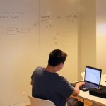 office with white walls, man working at desk