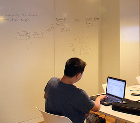 office with white walls, man working at desk