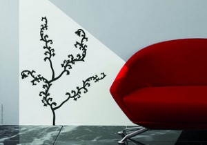 white wall with black tree outline next to modern red sofa