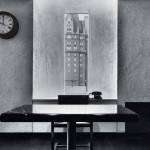 black and white photo of minimalist office with window and clock on wall